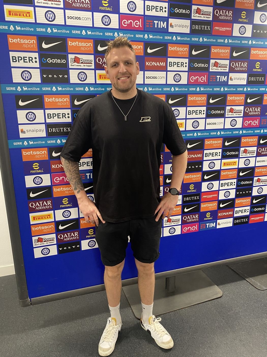 Sandro vor einer Sponsorenwand im Stadion